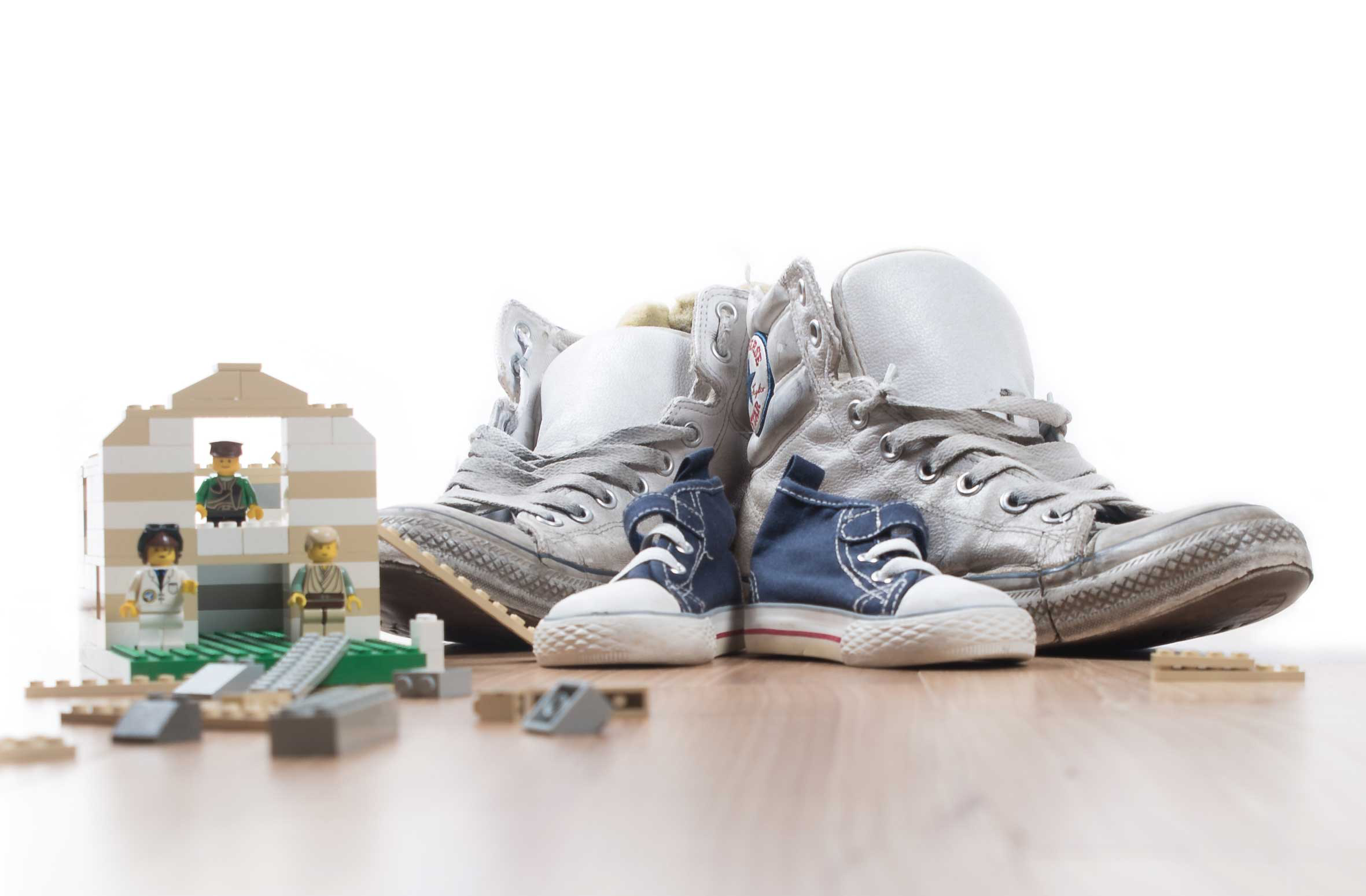 Frontbild med Legobitar och 2 par sneakers, typ Converse